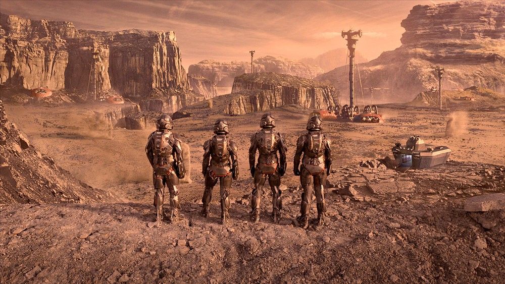 Still from the sci-fi TV series The Expanse. There are four people wearing armoured spacesuits looking at a city in the distance.