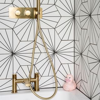 bathroom with black and white tiles and gold shower