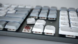 A close up shot of the Satechi SM3's navigation cluster with one of the arrow keys removed to show its low-profile brown mechanical switches