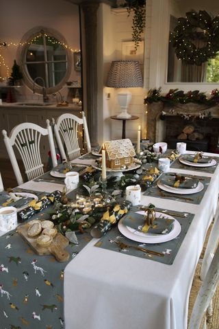 Christmas table with matching runner and napkins, crackers, mince pies, gingerbread house