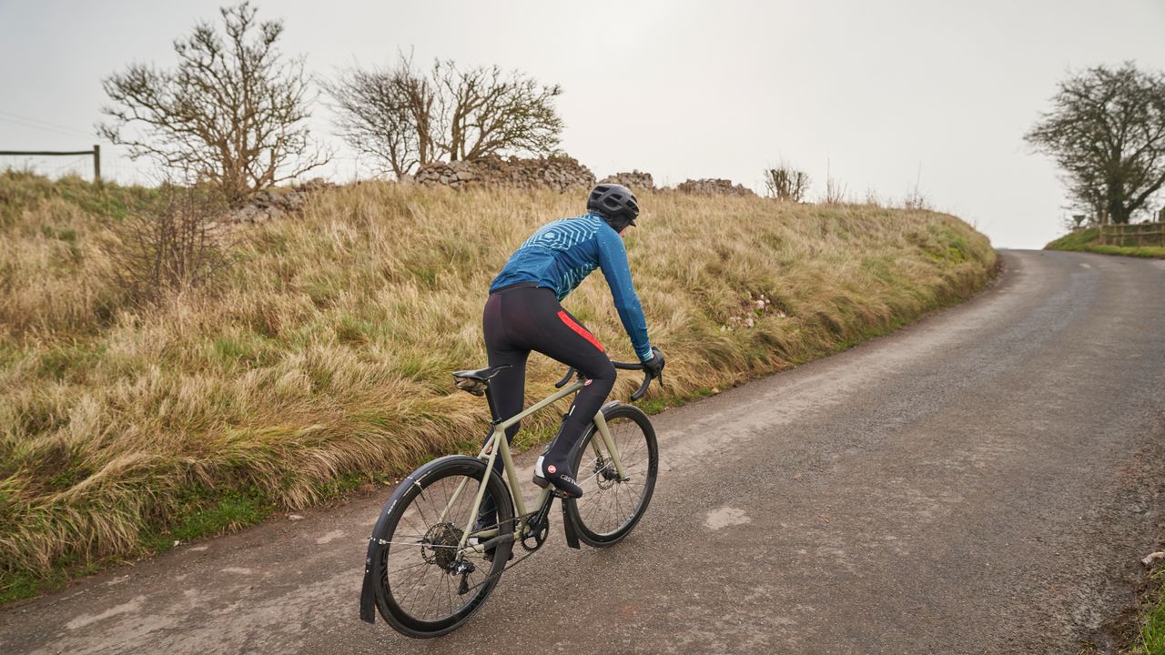 Image shows a person cycling during the winter