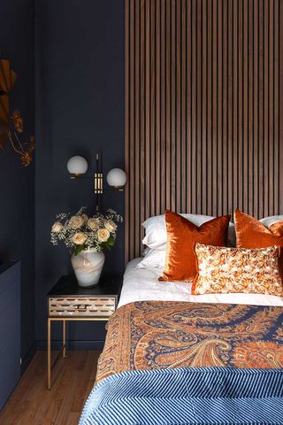 dark blue bedroom with wood slatted headboard