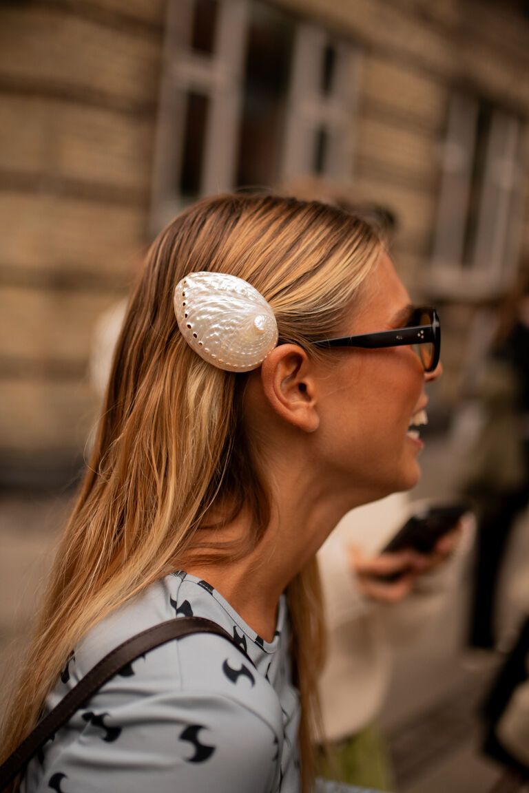 a woman wearing the shell motif jewelry summer 2026 trend at fashion week