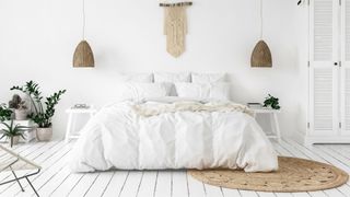 A scandi-style bedroom with white comforter on bed