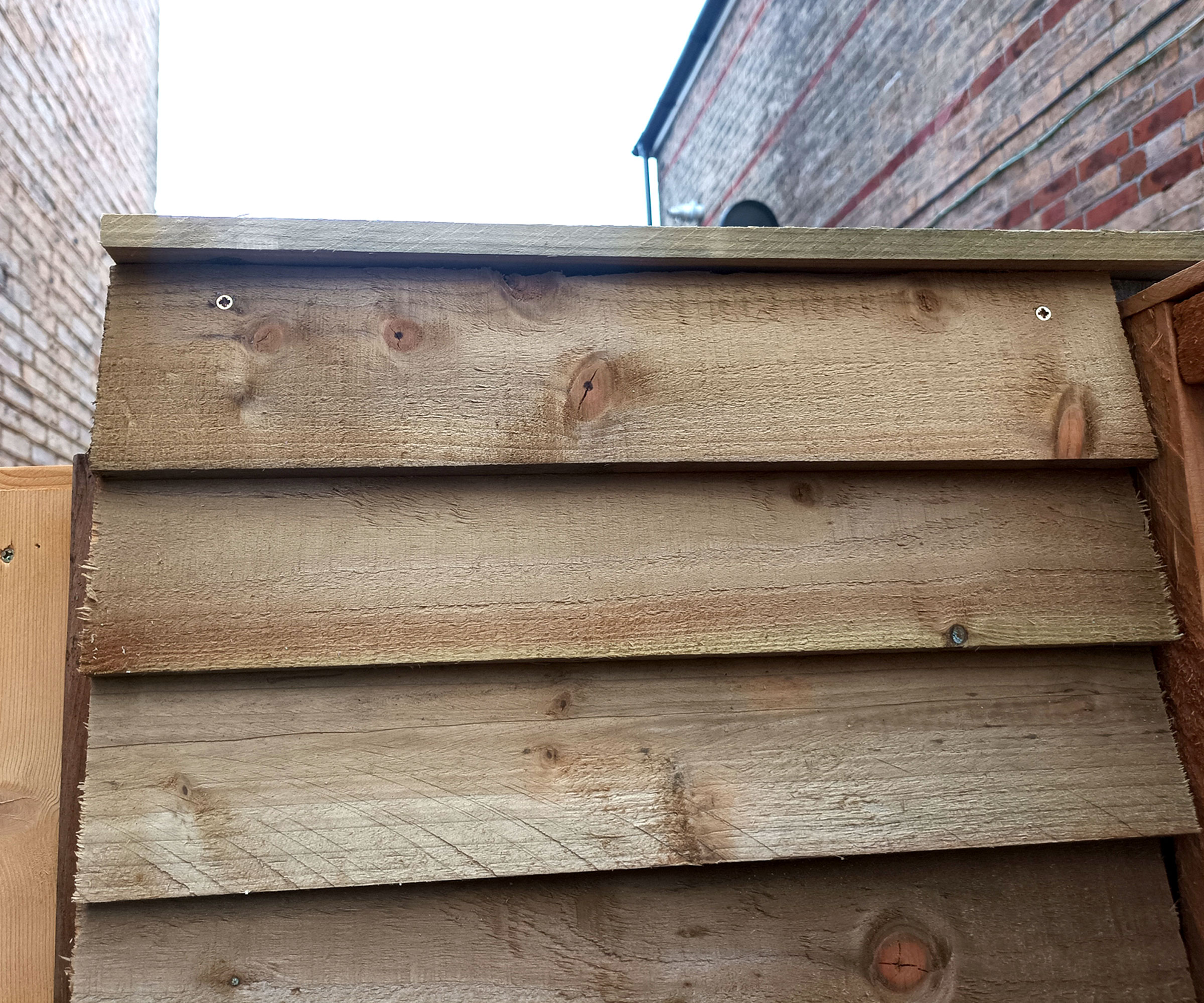 Top of narrow bespoke feather edge fence panel with boards running horizontally