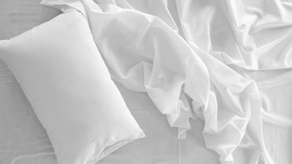 White pillow and bed sheets