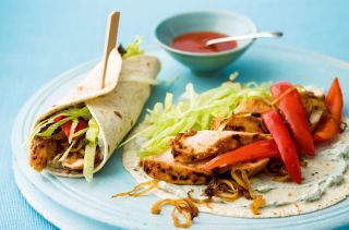 a wrap with grilled chicken, salad and satay sauce