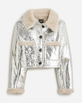 a limited-edition cropped shearling jacket in metallic leather on a plain backdrop