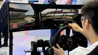 Man playing a racing game on Thermaltake GR500 Racing Sim Cockpit at Computex 2024.