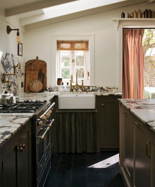 A dark kitchen with a marble worktop