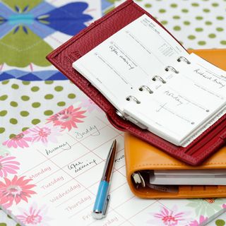 pen calendar and notebook on table with printed tablecloth