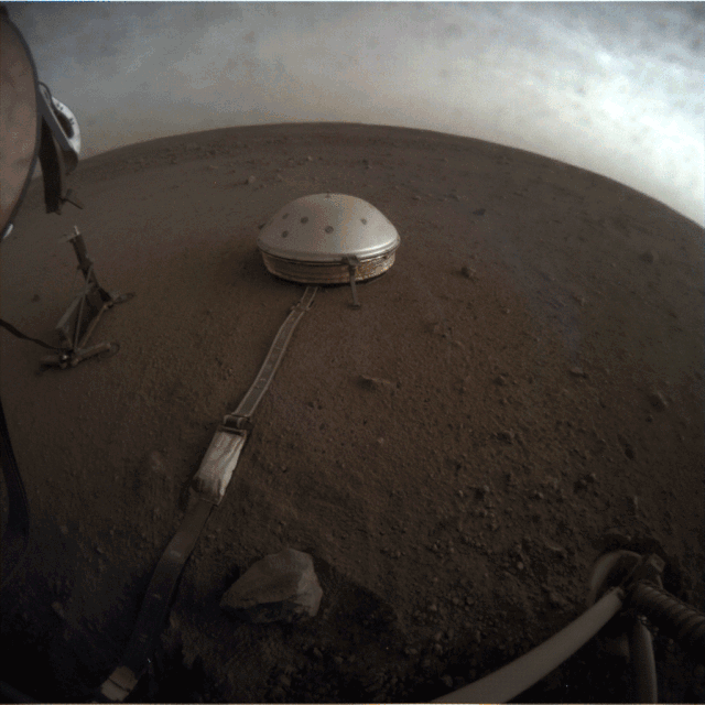 Grey clouds scoot across the Martian sky in this view from NASA's InSight lander. The spacecraft photographed the drifting clouds during a sunset on the Red Planet on April 25 using its Instrument Context Camera, which is mounted below the deck. Sitting on the dirt the foreground is the Seismic Experiment for Interior Structure (SEIS) instrument, which is looking for seismic activity, or "Marsquakes."
