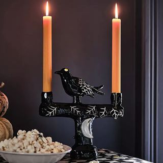 A Francesca Kaye Halloween Magic Candelabra with two lit ridged taper candles