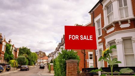 For sale sign in yard of house