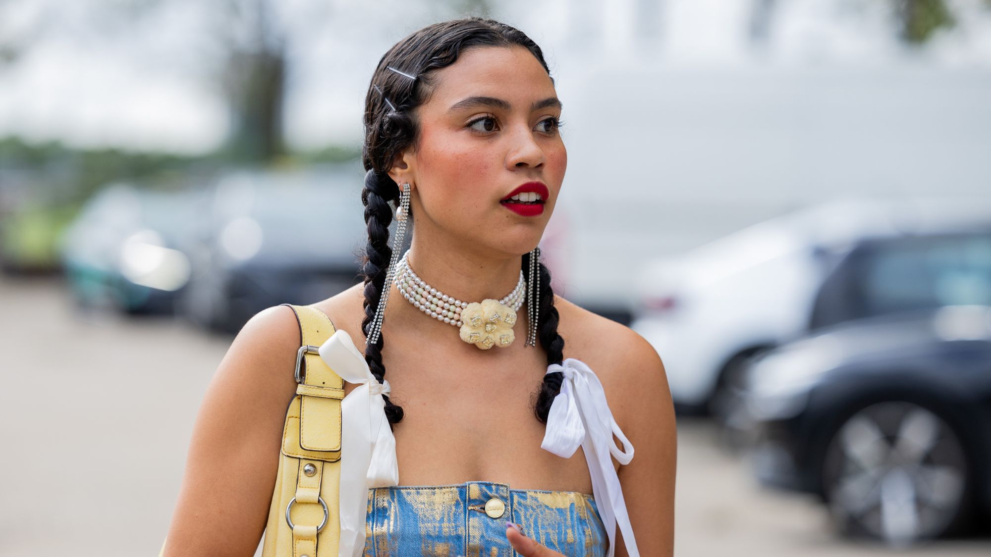 street style shot of woman with two plaits and red lipstick
