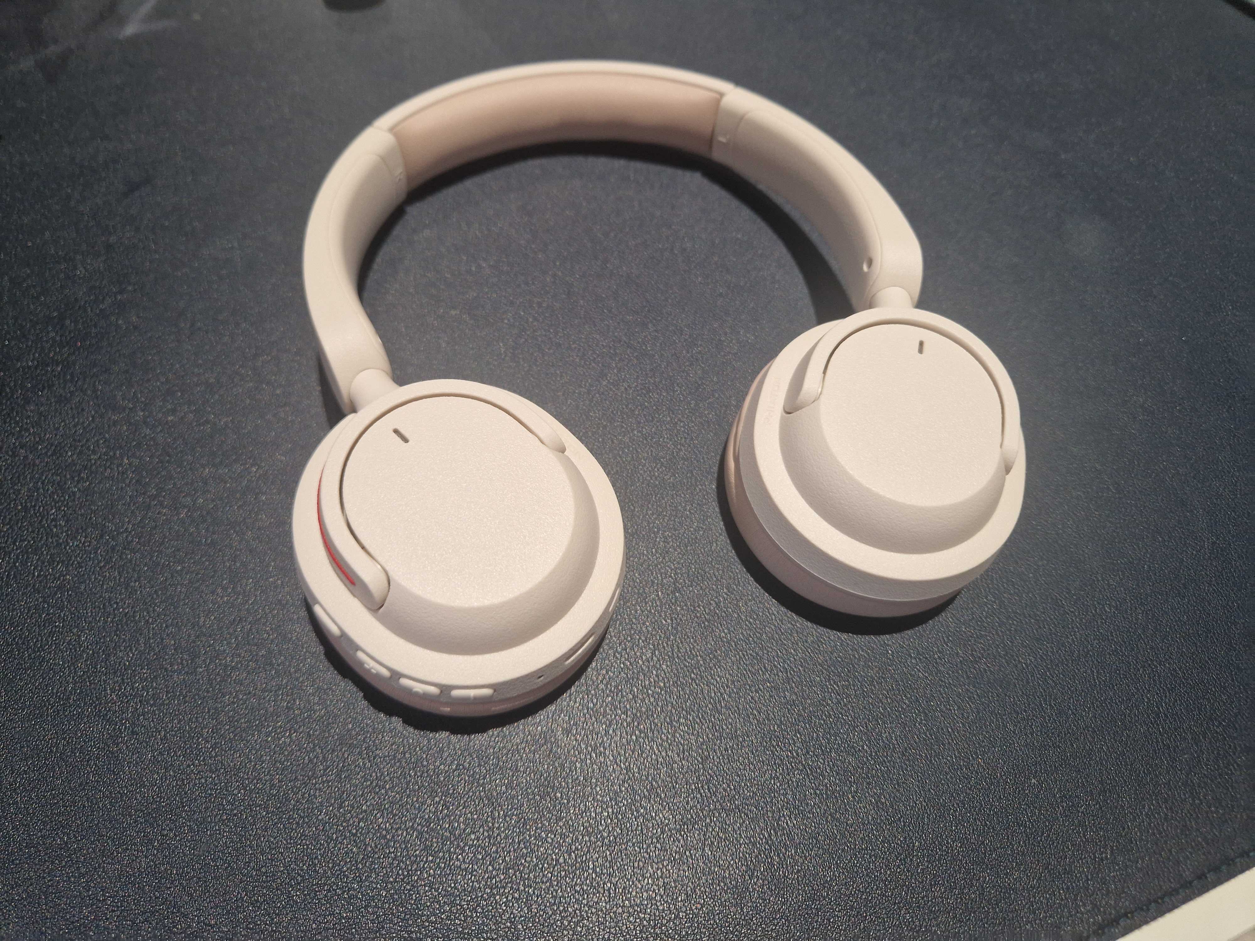 An off-white pair of BonoBeats Lite headphones sitting on a table