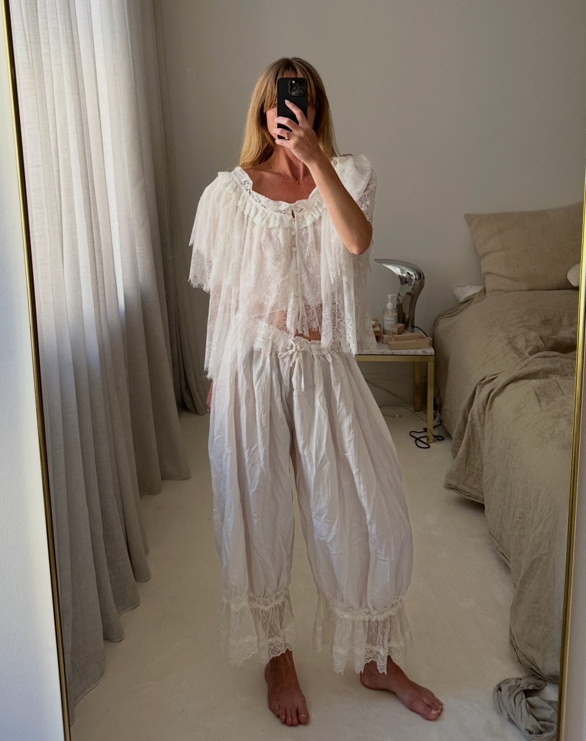 Jeanette Madsen in white embroidered hem pants.
