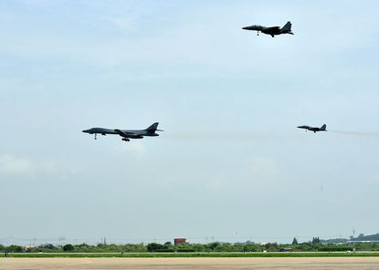 U.S. Air Force B-1B Lancer bomber (L) fly with South Korean fighter jet F-15K fighter jets over the Korean Peninsula