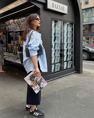 woman wearing black slip dress, button-down shirt, and sneakers outfit