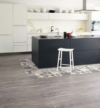 grey and white patterned tiles around a matte black kitchen island in a modern kitchen