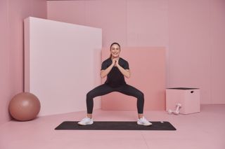 Kic app co-founder and personal trainer Steph Claire Smith demonstrating sumo squat pulses