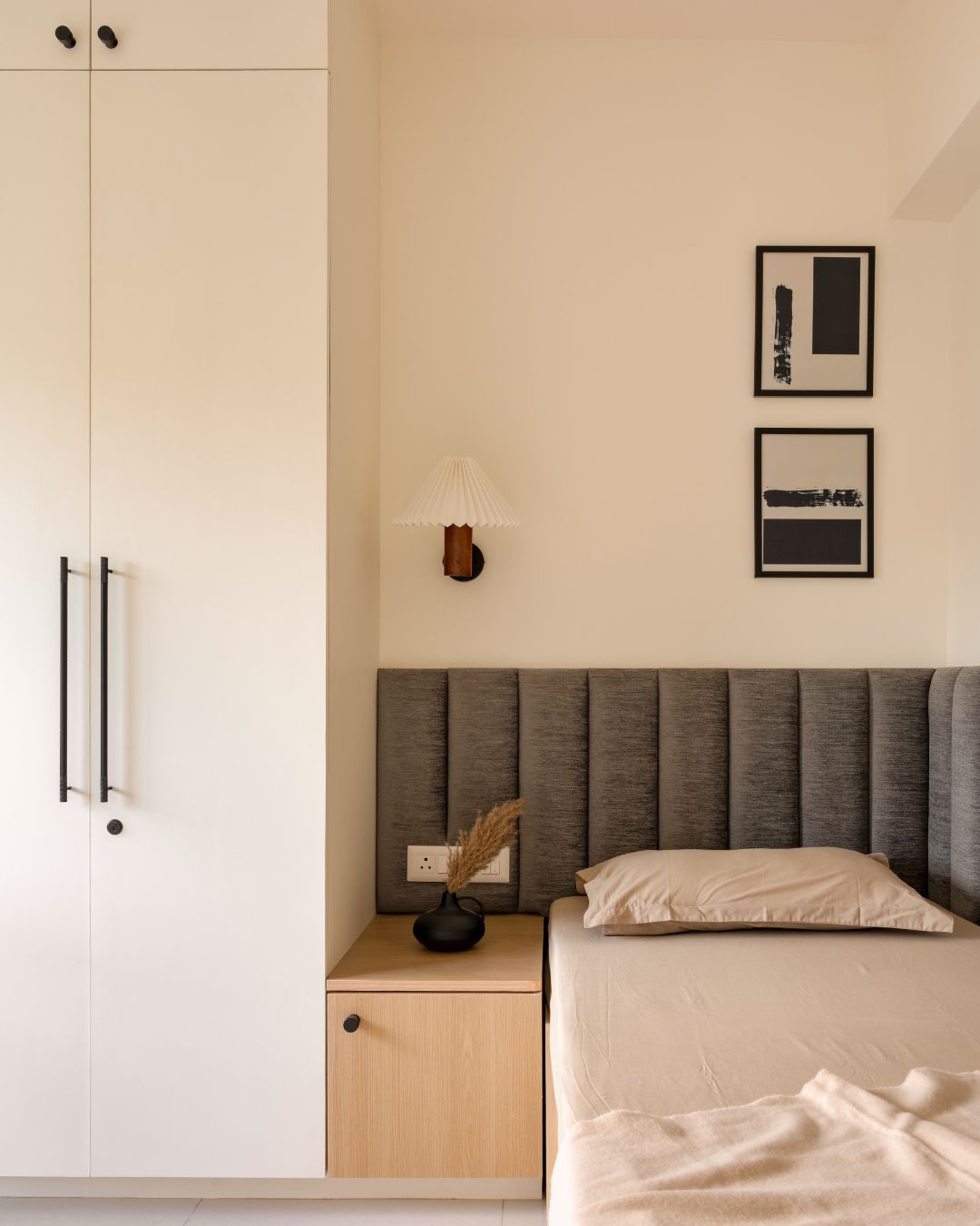 A bedroom with a single, in-built bed in the cornr, with a cabinet placed close to it