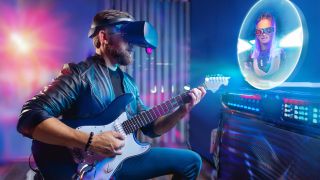 A man plays guitar with a VR headset on