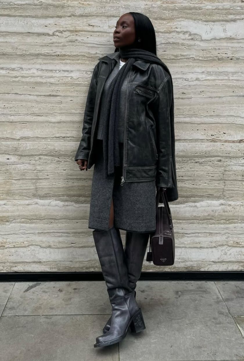 @daniellejinadu wears a grey wool skirt with a black leather biker jacket, heeled boots, tote bag and scarf