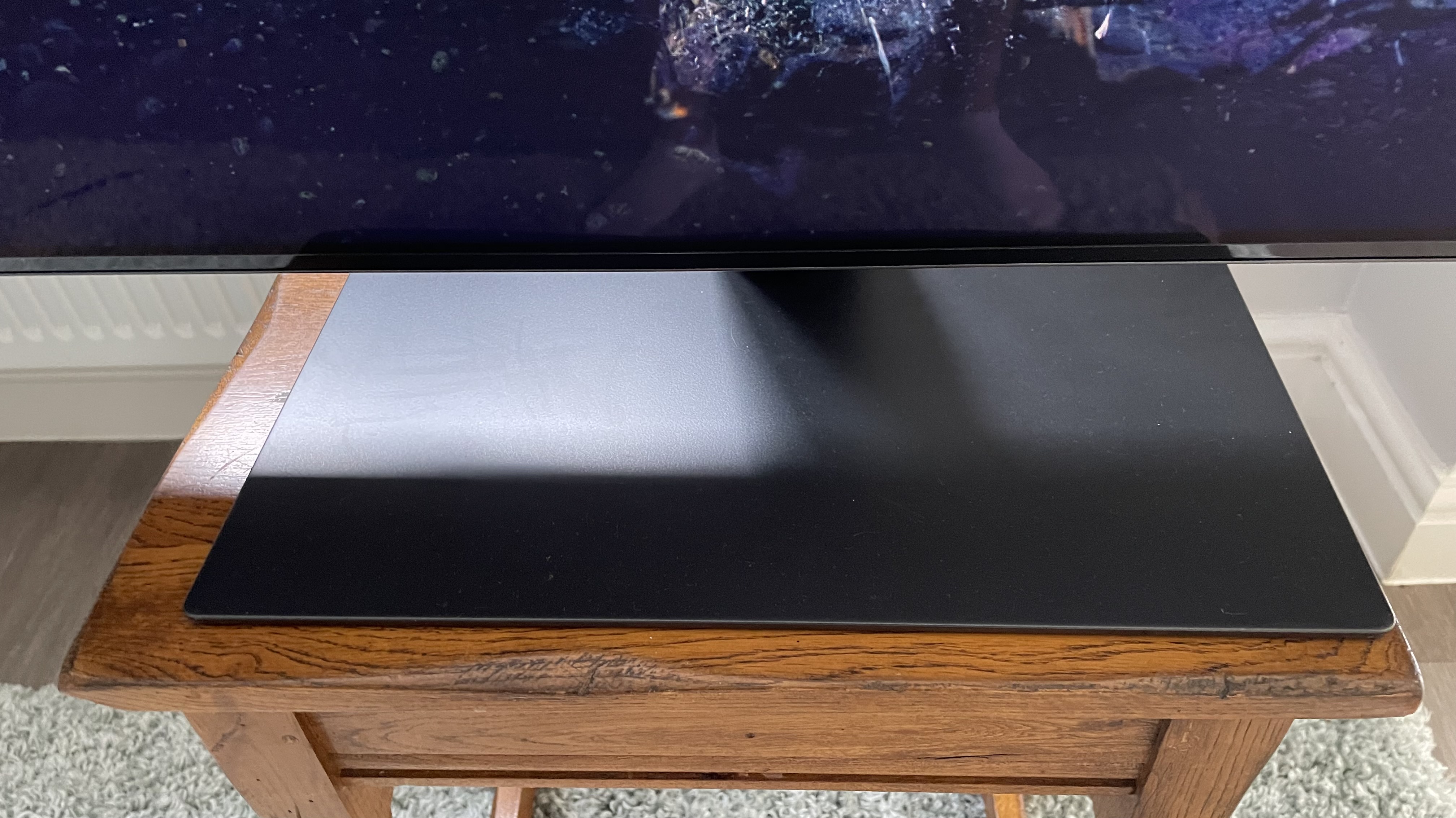 Samsung S95C OLED TV stand on wood table