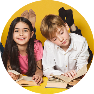 Image of a boy and a girl lying on the floor reading their books