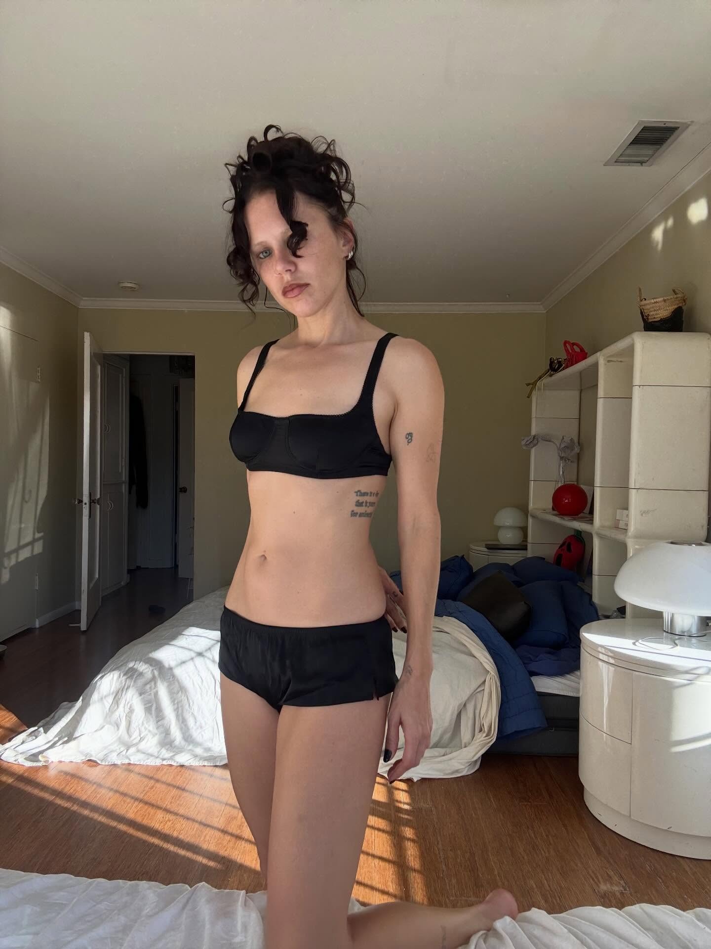 @alwaysjudging wearing a black silk lingerie set from Araks.