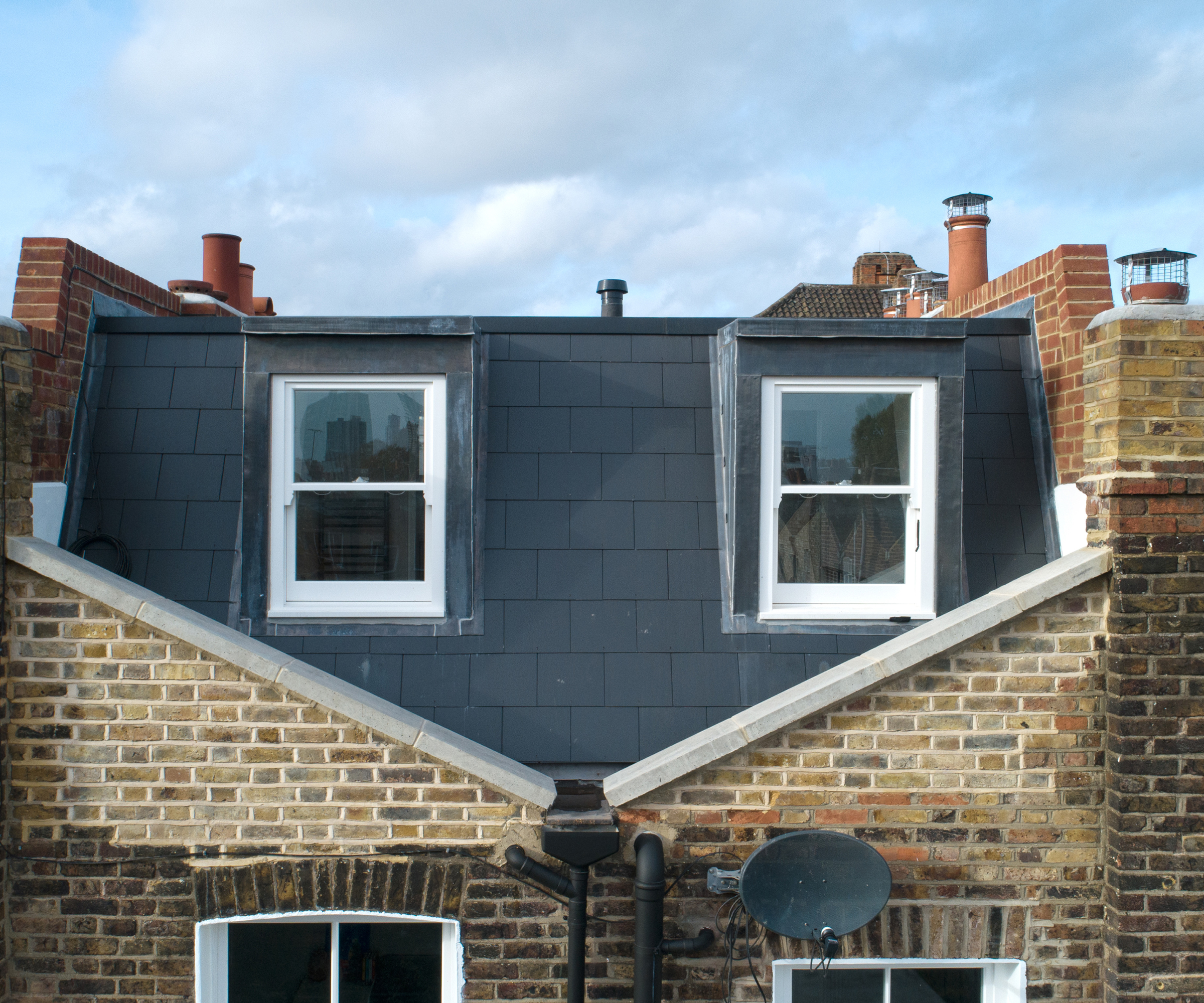 external view of loft conversion positioned in centre of butterfly roof structure