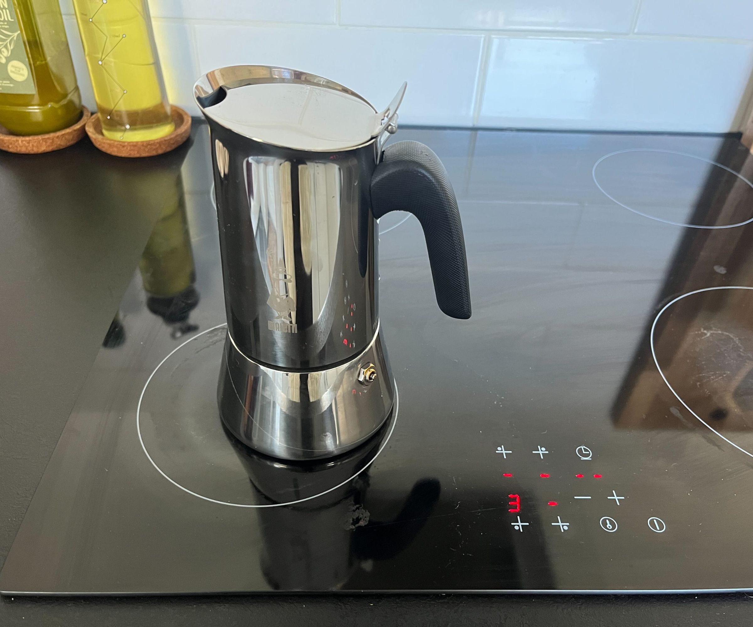 The stainless steel Bialetti Venus Moka pot on a black electric stove