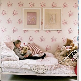 girls pink bedroom with floral wallpaper wrought iron bedframe