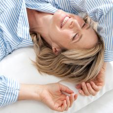 woman lying on bed - best pillow sprays