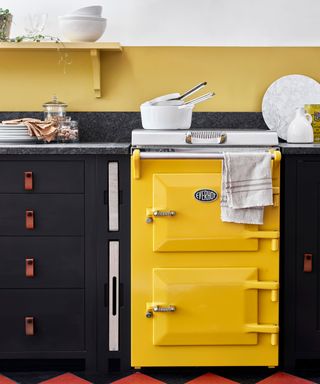 black kitchen units with yellow oven