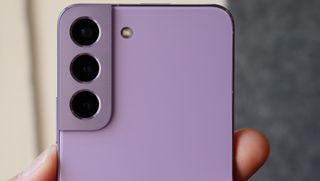 En närbild på kameramodulen på baksidan av en Samsung Galaxy S22 i färgen Bora Purple.