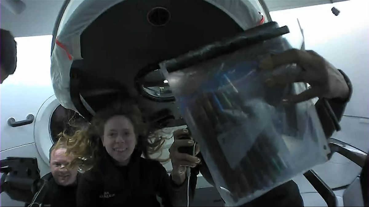 Sian Proctor holds up a bag of metallic markers that she brought to space to make art in orbit.