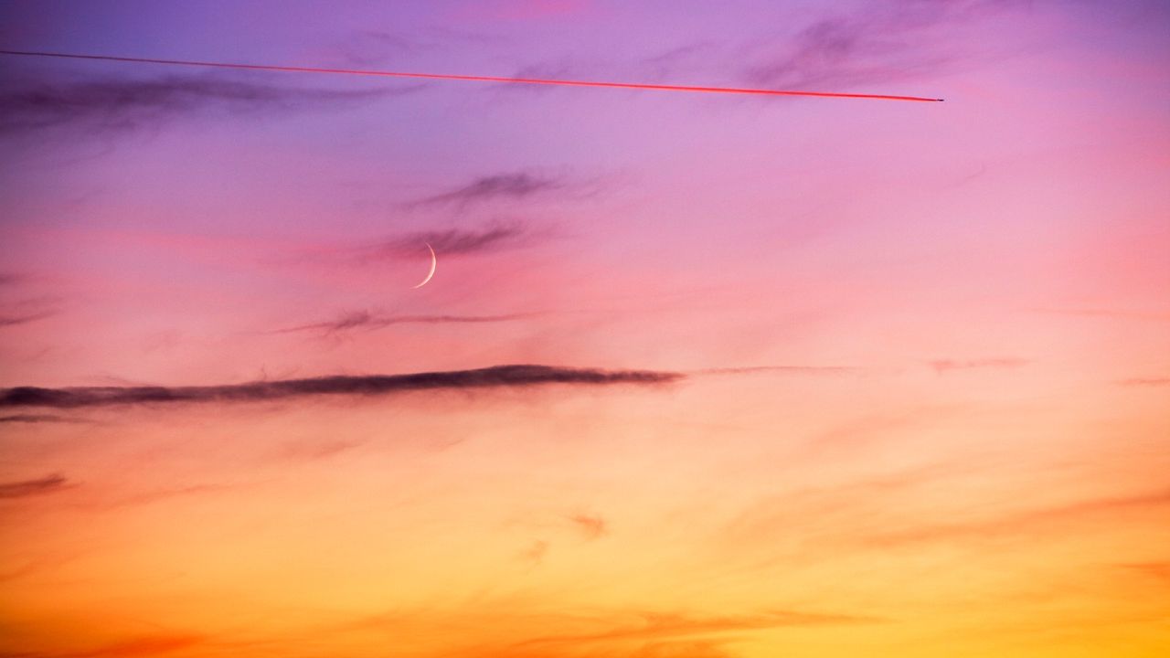 October New Moon—New Moon and plane contrail at sunset near Windermere, UK.