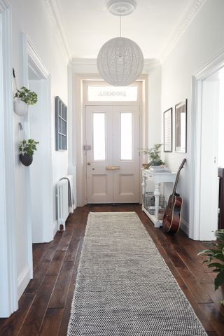 white scheme hallway with large front door and use of natural light