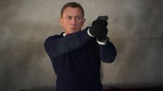 Daniel Craig as James Bond holding a gun