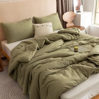 Rosognia Comforter Set in olive green on a bed.