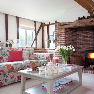 living room with wooden beams on wall brick fireplace and designed sofa