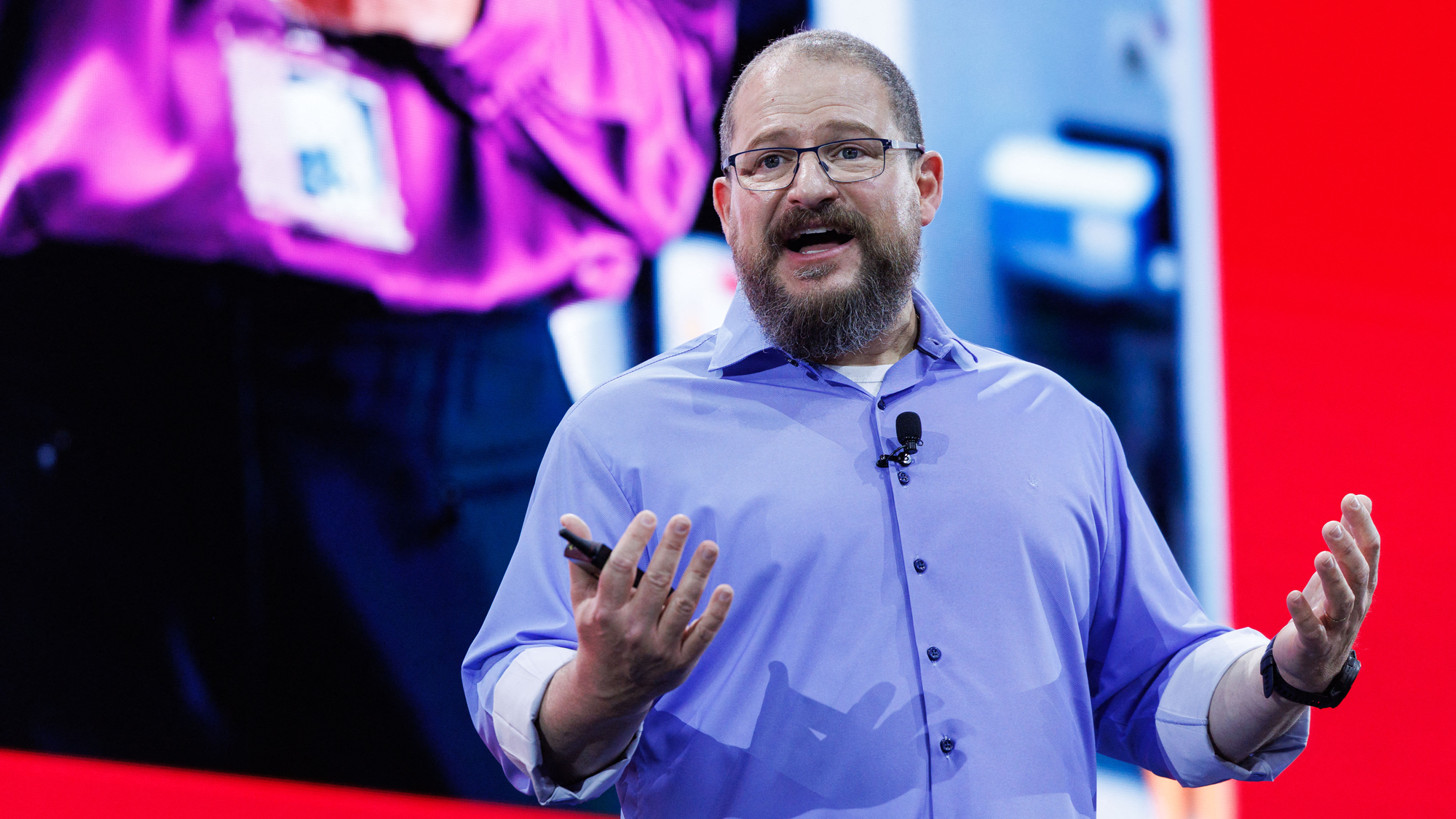 Qualcomm CEO Cristiano Amon speaks at Computex 2025 in Taipei on May 19, 2025. He is wearing a blue shirt and holding his hands out in front of him. 