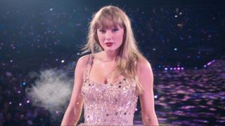 Taylor Swift walking down the stage and looking into the camera while performing Enchanted during the Eras Tour. 