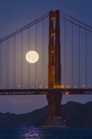 The supermoon sets behind the south tower of the Golden Gate Bridge in this photo by astrophotographer Kwong Liew.