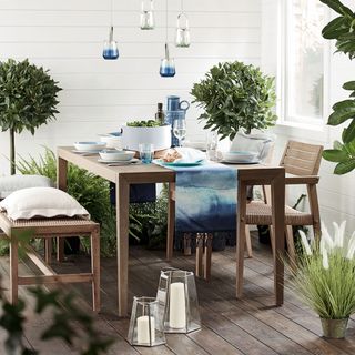 dining area with dining table and bench with chairs and candle glass jar with plants on pots