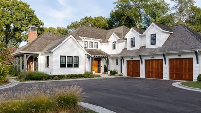 Exterior shot of L-shape home with peaked eaves, triple garage and driveway
