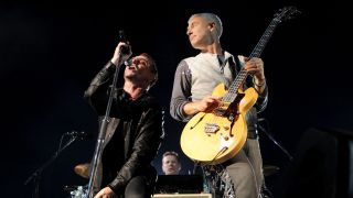 Musicians Bono, Larry Mullen and Adam Clayton of the band U2 perform at Rose Bowl during their U2 360 Tour on October 25, 2009 in Pasadena, California.