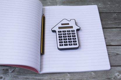 mortgage advisor advice: book with calculator shaped like a house